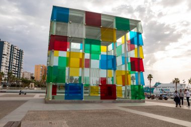 Malaga, Spain - November 17, 2024: The colored glass cube is a contemporary art center at the Center Pompidou in Malaga clipart