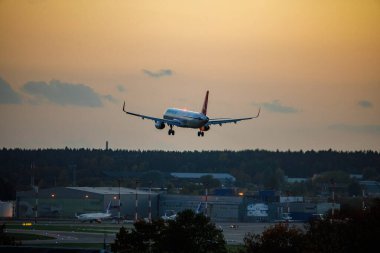 Vilnius, Lithuania - October 6, 2022: Airplane Landing at Vilnius Airport During Sunset clipart