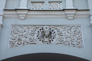 Süslü çiçek desenleri ve insan yüzü ile karışık mimari rahatlama Vilnius, Litvanya 'nın Vilnius sokağındaki tarihi bina