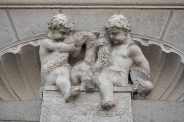 Litvanya, Vilnius 'ta tarihi yapı cephesinde çelenk tutan meleklerin dekoratif mimari heykeli