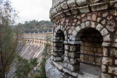 Historic arch dam of Embalse del Conde de Guadalhorce in Malaga, Spain, surrounded by nature and scenic landscape clipart