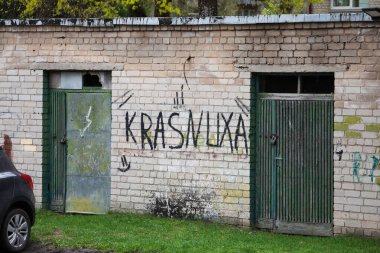 Vilnius, Litvanya - 13 Nisan 2024: KRASNUXA, Vilkpede bölgesindeki Krasnucha olarak bilinen iki eski metal kapı arasındaki eskimiş tuğla duvara sprey boyayla boyandı