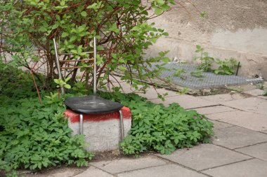 Litvanya 'nın Vilnius semtinde Sovyet döneminden kalma zengin kalıntılarıyla Krasnucha olarak bilinen aşırı gelişmiş bir yeşilliğin ortasına kurulmuş eski bir koltuk ve beton bloktan yapılmış bir sandalye.