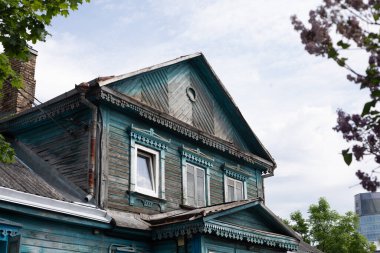 Litvanya, Vilnius 'un Zverynas bölgesindeki süslü pencere süslemeleri ve karmaşık mimari unsurları olan geleneksel, yıpranmış ahşap bir evin ayrıntılı görüntüsü. 