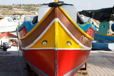 Marsaxlokk, Malta - 11 Ekim 2023: Osiris 'in ikonik gözlerinin pruvada yer aldığı geleneksel parlak boyalı luzzu balıkçı teknesinin yakın görüntüsü.