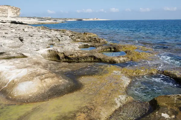 Aziz Peter Havuzu 'nun engebeli, dokulu kireçtaşı kıyı şeridi uçsuz bucaksız gökyüzünün altında açık mavi Akdeniz ile buluşur, Malta