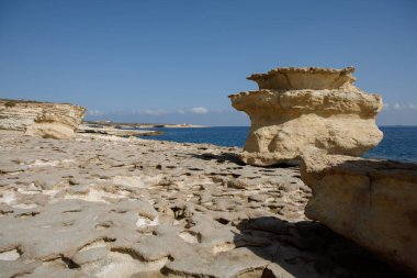 Aziz Peter Havuzu 'nun engebeli, dokulu kireçtaşı kıyı şeridi uçsuz bucaksız gökyüzünün altında açık mavi Akdeniz ile buluşur, Malta