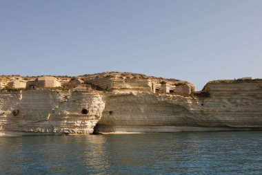 Aziz Peter Havuzu 'nun engebeli, dokulu kireçtaşı kıyı şeridi uçsuz bucaksız gökyüzünün altında açık mavi Akdeniz ile buluşur, Malta