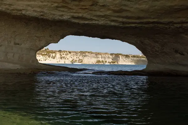 Aziz Peter Havuzu 'nun doğal kemeri Akdeniz turkuazını ve uzak uçurumları çerçeveler.