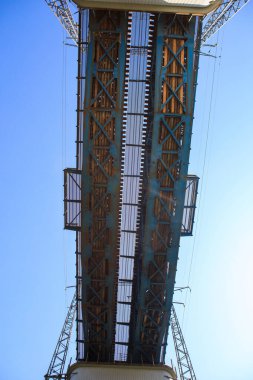 Traku Voke, Vilnius, Litvanya 'daki çelik demiryolu köprü yapısının yakın plan alt perspektifi, açık mavi gökyüzüne karşı kirişleri, perçinleri ve mühendislik tasarımlarını gösteriyor