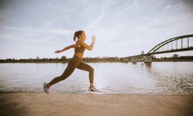 Nehir boyunca çalışan aktif genç güzel kadın, görüntüleme