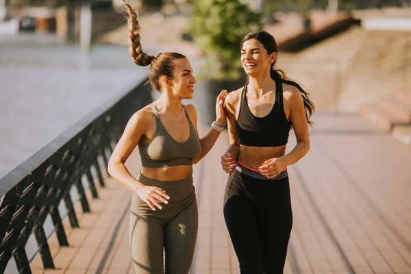 stock image Pretty young woman taking running exercise by the river promenade