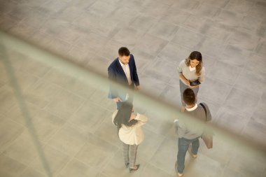 Genç iş adamlarının hava görüntüsü ofis koridorunda tartışılıyor.