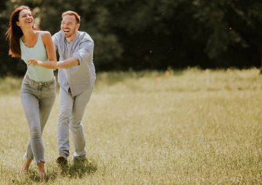 Bir yaz günü çim tarlasında aşık mutlu genç bir çift