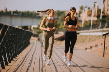 Güzel genç bayan nehir kenarında koşuya çıkıyor.