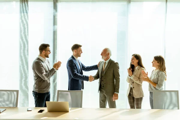 お近くの従業員と契約を締結した後 事務所で握手をするお取引先 — ストック写真