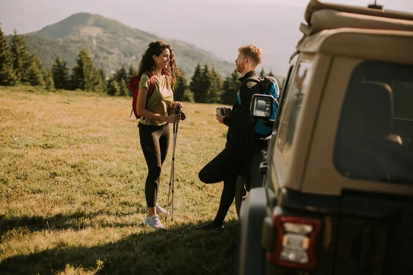 Smiling Young Couple Preparing Hiking Adventure Backpacks Terrain Vehicle — Stockfoto