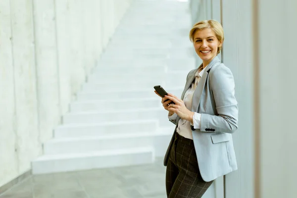 Geschäftsfrau Benutzt Handy Stehen Auf Dem Modernen Büroflur — Stockfoto