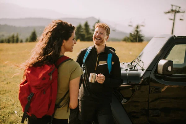 Smiling Young Couple Preparing Hiking Adventure Backpacks Terrain Vehicle — Fotografia de Stock