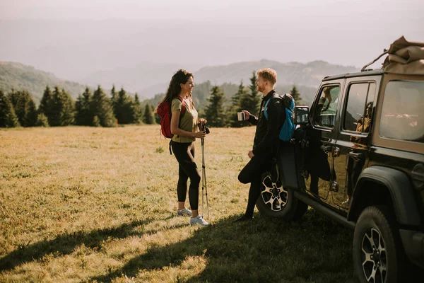 Smiling Young Couple Preparing Hiking Adventure Backpacks Terrain Vehicle — Foto de Stock