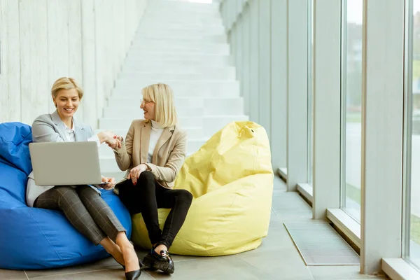 Duas Mulheres Negócios Trabalhando Laptop Sacos Preguiçosos Escritório Moderno — Fotografia de Stock