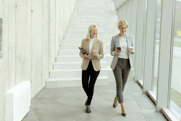 Twee Zakenvrouwen Lopen Met Digitale Tablet Mobiele Telefoon Kantoorgang — Stockfoto