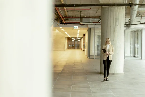 現代のオフィス廊下にデジタルタブレットを持つビジネスマン女性 — ストック写真