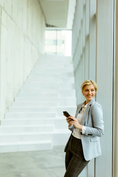 Businesswoman Using Mobile Phone While Standing Modern Office Hallway — Stock Photo, Image