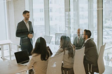 Handsome young businessman presenting results to his coleagues in the office