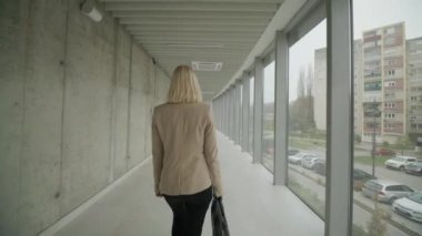 Modern ofis koridorunda yürüyen iş kadını