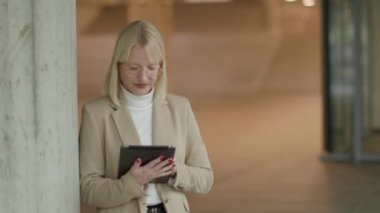 Modern ofis koridorunda dijital tabletli iş kadını