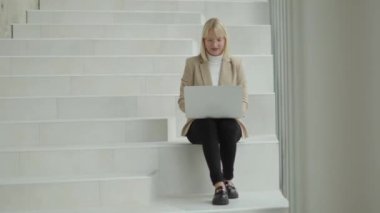 Modern ofiste iş kadını laptopta tembel çanta üzerinde çalışıyor.