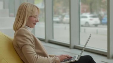 Modern ofiste iş kadını laptopta tembel çanta üzerinde çalışıyor.