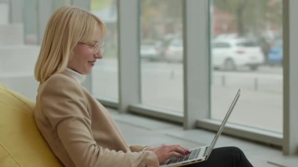 在现代化的办公室里 女商人在手提电脑上懒洋洋地干活 — 图库视频影像