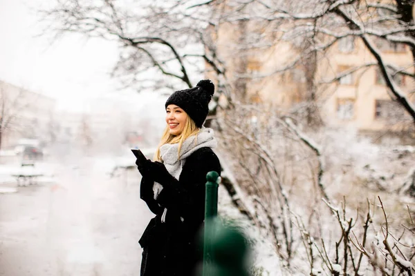 Pretty Young Woman Warm Clothes Enjoying Snow Using Mobile Phone — Stockfoto