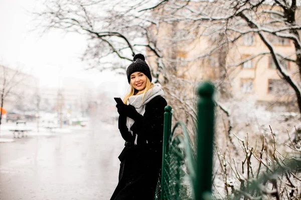 Hübsche Junge Frau Warmer Kleidung Genießt Schnee Und Benutzt Handy — Stockfoto