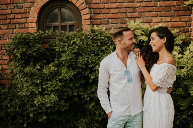 Happy young couple is enjoying the beautiful surroundings of a garden, basking in the sun and each other's company