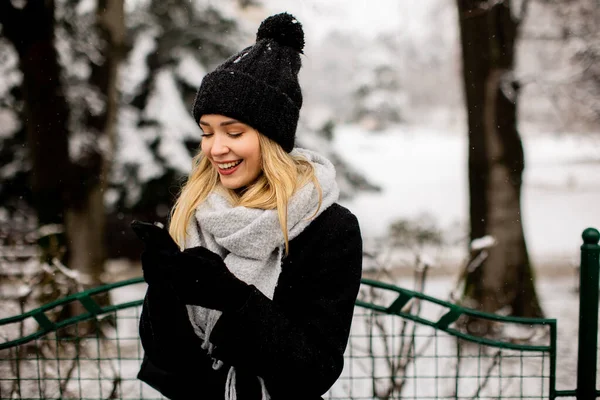 Kaunis Nuori Nainen Lämpimissä Vaatteissa Matkapuhelimella Talvipäivänä — kuvapankkivalokuva