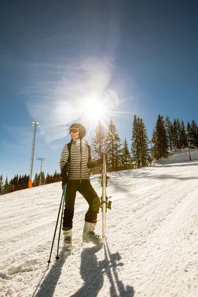 1人の若い女性がスキーブーツとサングラスで完全な雪のギアを身に着けているスキーの晴れた冬の日を楽しんでいます — ストック写真