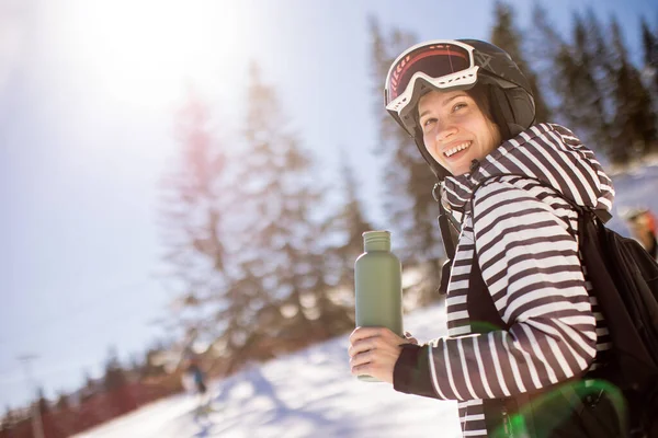 年轻女子在雪地上享受着冬日的滑雪 雪地上覆盖着山坡 四周长满了高大的树木 穿着寒冷的衣服 — 图库照片
