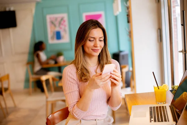Mujer Bastante Joven Usando Teléfono Móvil Mientras Trabaja Ordenador Portátil — Foto de Stock