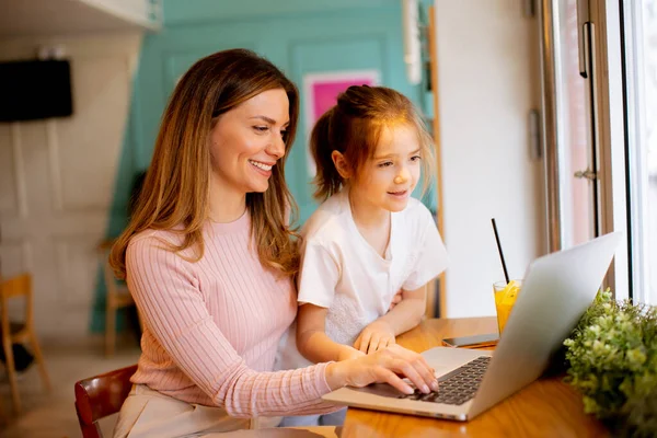 Hübsche Junge Mutter Und Ihre Tochter Arbeiten Laptop Und Trinken — Stockfoto