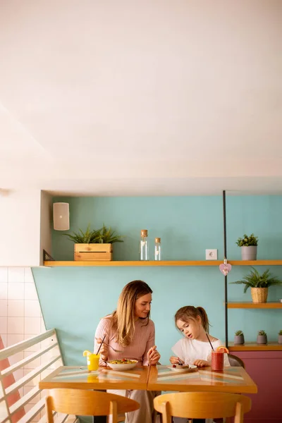 母と娘あります楽しい時間間に朝食とともに新鮮な絞り汁でカフェ — ストック写真
