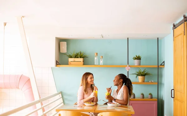 Duas Mulheres Negras Caucasianas Muito Jovens Divertindo Bebendo Sucos Frescos — Fotografia de Stock