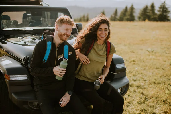 Smiling Young Couple Preparing Hiking Adventure Backpacks Terrain Vehicle — Fotografia de Stock