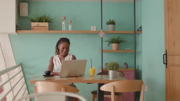 年轻漂亮的黑人女人在咖啡店边工作边吃着健康的早餐 — 图库视频影像