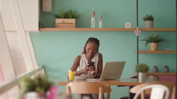 年轻漂亮的黑人女人在咖啡店边工作边吃着健康的早餐 — 图库视频影像
