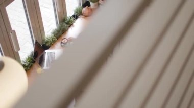 Dizüstü bilgisayarda çalışan ve kafede kahve içen üst düzey bir kadın.