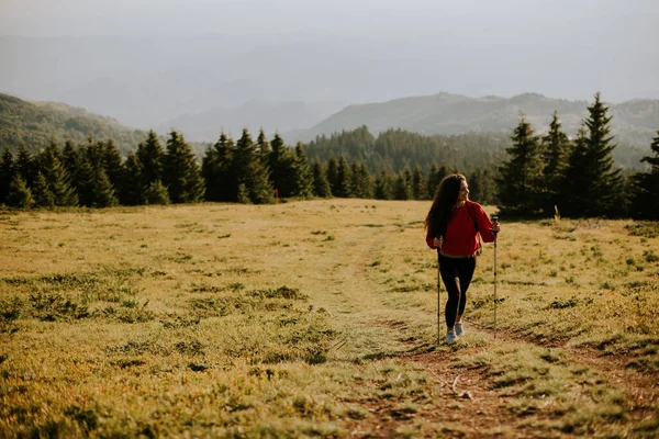Sırt Çantasıyla Yeşil Tepelerde Yürüyen Gülümseyen Genç Kadın — Stok fotoğraf