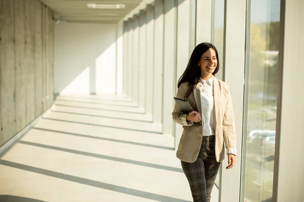晴れた日に近代的なオフィスの廊下を歩く若いビジネスマンの女性 — ストック写真